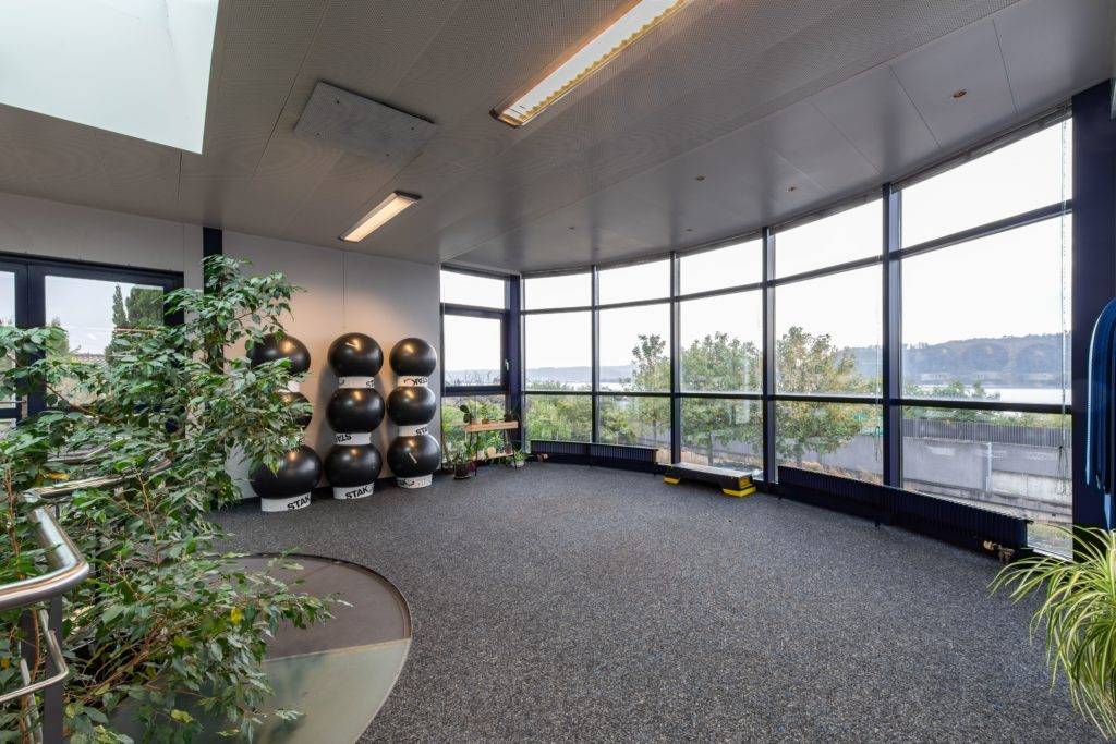 Salle d’entraînement lumineuse du centre de coaching sportif Liberty-Training au Landeron avec grandes baies vitrées et espace fonctionnel.